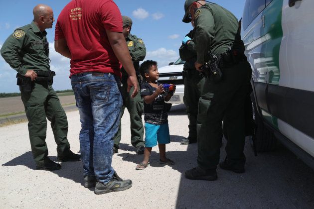 国境近くで拘束される、ホンジュラスから来た男の子と父親。2018年6月12日、テキサス州ミッションで撮影。