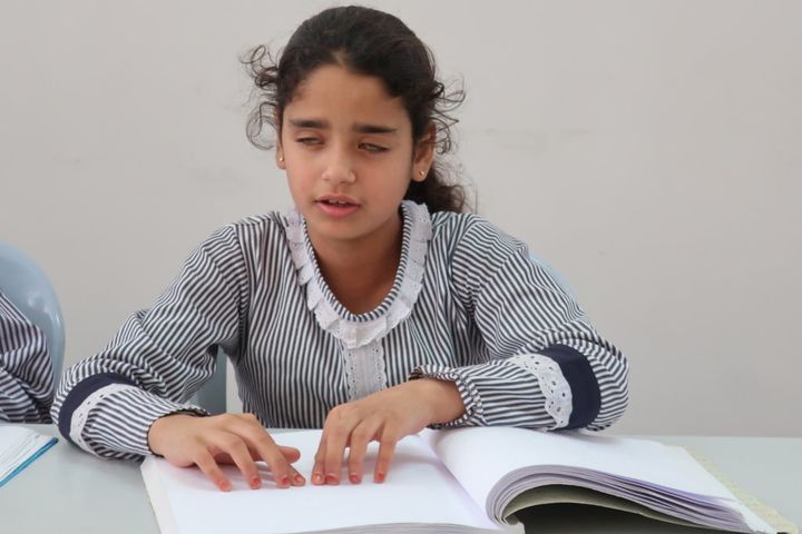 点字を読む難民少女。ガザにある視覚障害者のためのリハビリセンター（RCVI）で