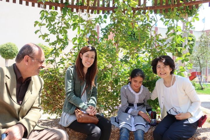 学校の校庭で夢を語るハーラさんを囲んで。左から校長先生、吉田UNRWA渉外・プロジェクト支援担当官、妹尾 