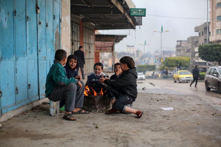 大雨の後の冷え込んだ日、自宅には暖房もなく通りで共に暖を取るガザの子どもたち