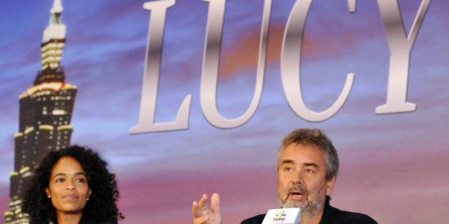 French director Luc Besson (R) speaks as his wife French producer Virginie Silla (L) listens during a press conference in Taipei on November 1, 2013. French director Luc Besson on November 1 rejected reports that his new movie 'Lucy' was about a drug mule and that he was ready to end shooting in Taipei after being harassed by paparazzi. AFP PHOTO / Mandy CHENG (Photo credit should read Mandy Cheng/AFP/Getty Images)