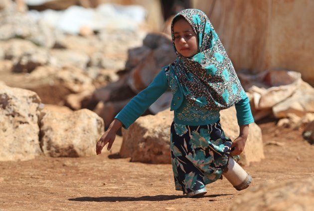 キャンプ内を空き缶の義足で歩くマヤ・メルヒさん＝6月20日、シリア・イドリブ