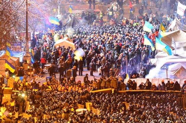 ヤヌコビッチ政権に反対する集会参加者（奥）と衝突する警察隊（手前）＝2013年12月、キエフ