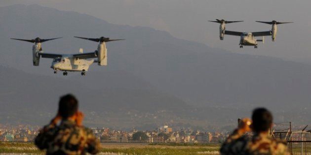 Nepalese soldiers take pictures as US Air Force Bell Boeing V-22 Osprey aircrafts arrive at the Tribhuvan International airport in Kathmandu, Nepal, Sunday, May 3, 2015. Runway damage forced Nepalese authorities to close the main airport Sunday to large aircraft delivering aid to millions of people following the massive earthquake, but U.N. officials said the overall logistics situation was improving. Airport congestion was only the latest complication in global efforts to aid people in the wake of the April 25 quake, the impoverished country's biggest and most destructive in eight decades. (AP Photo/Niranjan Shrestha)