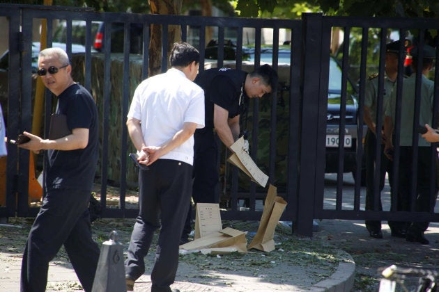 A security personnel removes objects near the U.S. embassy in Beijing, China July 26, 2018. REUTERS/Thomas Peter