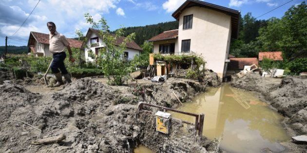 A man walks out from his mud covered front yard in Krupanj, some 130 kilometres south west of Belgrade, on May 20, 2014, after it was hit with floods and landslides, cutting the western Serbian town off for four days. Serbia declared three days of national mourning on May 20 as the death toll from the worst flood to hit the Balkans in living memory rose and health officials warned of a possible epidemic. At least 49 people have been killed already by the worst floods in central Europe for a century and more than 1.6 million people have been hit as the river Sava and its tributaries have burst their banks, inundating tens of thousands of hectares of farmland and destroying houses and buildings. AFP PHOTO / ANDREJ ISAKOVIC (Photo credit should read ANDREJ ISAKOVIC/AFP/Getty Images)