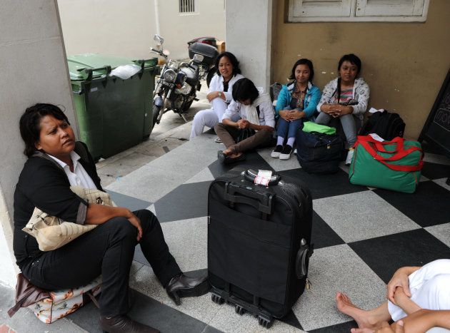 シンガポールに到着し、家政婦としての登録を待つインドネシアの出稼ぎ労働者たち＝2012年