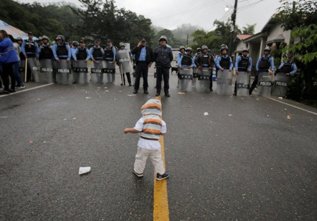 道路を封鎖する警官たちと、移民の子ども