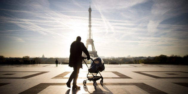 A person walks with baby-buggy in front of the Eiffel tower on November 11, 2013 at the Trocadero in Paris. AFP PHOTO / LIONEL BONAVENTURE (Photo credit should read LIONEL BONAVENTURE/AFP/Getty Images)