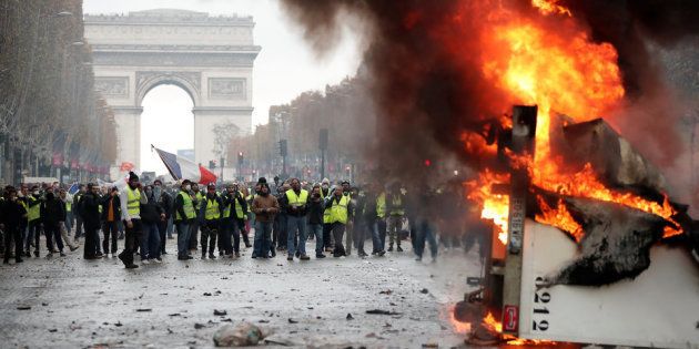 パリ・シャンゼリゼ通りでトラックを燃やすデモ隊