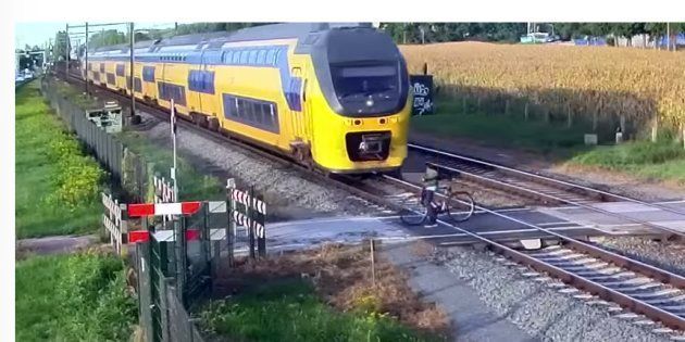 踏切内で、自転車が列車と接触しそうになる瞬間