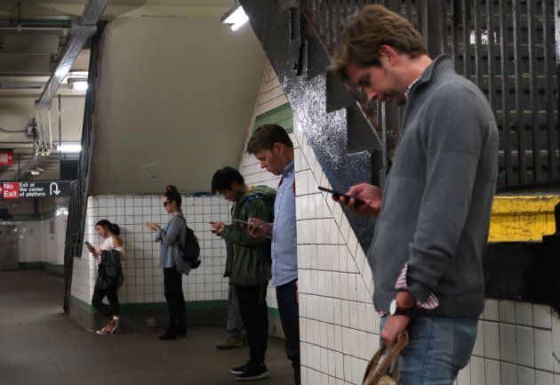 地下鉄でスマートフォンを利用するイメージ写真