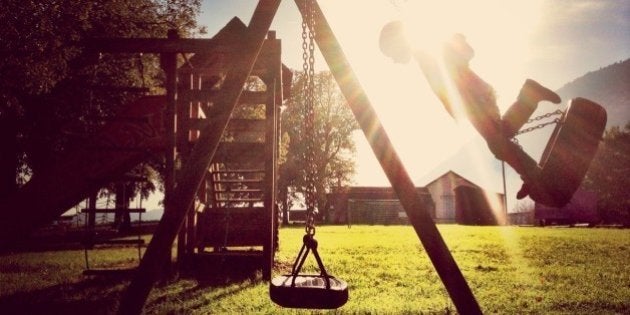 Boy On Tire Swing In Playground