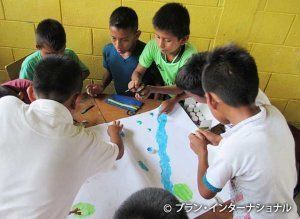 「暴力のない村」をテーマに絵を描く男の子たち