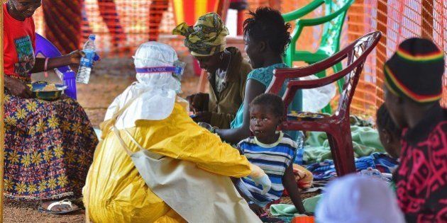An MSF medical worker feeds an Ebola child victim at an MSF facility in Kailahun, on August 15, 2014. Kailahun along with Kenama district is at the epicentre of the world's worst Ebola outbreak. The World Health Organisation (WHO) revealed that the latest death toll from the Ebola virus in Guinea, Sierra Leone, Liberia and Nigeria had claimed more than1000 lives. Health Organizations are looking into the possible use of experimental drugs to combat the latest outbreak in West Africa. AFP PHOTO/Carl de Souza (Photo credit should read CARL DE SOUZA/AFP/Getty Images)