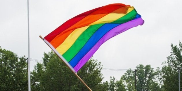 Principal Pete Cahall, waves a rainbow flag, symbolizing gay pride, at a rally of about 1000 Woodrow Wilson High School students and gay supporters June 9, 2014 at Woodrow Wilson High School in Washington, DC. The rally was held to counter a planned protest by Westboro Baptist Church, the Kansas-based organization known for anti-gay picketing at funerals. AFP PHOTO/Paul J. Richards (Photo credit should read PAUL J. RICHARDS/AFP/Getty Images)