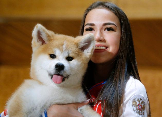 秋田犬のマサルを抱っこするアリーナ・ザギトワ選手＝2018年5月26日、モスクワ