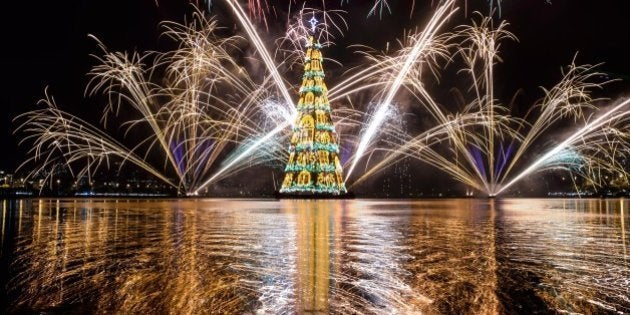 View of fireworks during the inauguration of an 85-meter-high floating Christmas tree at Rodrigo de Freitas lagoon in Rio de Janeiro, Brazil, on November 29, 2014. The world highest floating Christmas tree registered by the Guinness World Records was inaugurated for its 19th time Saturday night and will be illuminated by 3.1 million lights every night until the end of the year. AFP PHOTO / YASUYOSHI CHIBA (Photo credit should read YASUYOSHI CHIBA/AFP/Getty Images)