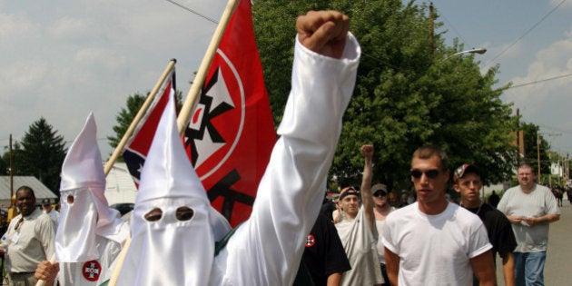 Members of the World Knights of the Ku Klux Klan as they march along a street, Saturday, Aug. 28, 2004, in Sharpsburg, Md. The participants in the march were outnumbered by more than two dozen police in riot gear who kept the Klansmen away from scores of people gathered in a downtown intersection. The police escorted the marchers to a city park, but kept the public away. (AP Photo/Timothy Jacobsen)