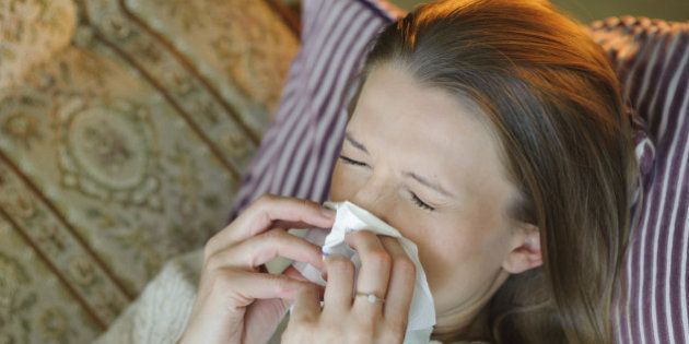 Cold flu illness of woman - tissue blowing runny nose at home