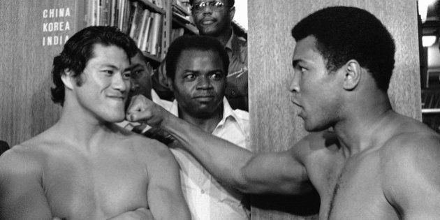 Antonio Inoki smilingly takes it on the chin as Muhammad Ali show newsmen what he will be aiming for when they fight each other next week. The byplay came before a luncheon at the Foreign Correspondents Clue of Japan in Tokyo on Friday, June 18, 1976 during what was called a ?Preliminary weighin?. The rear, or official weighin will take place the day before their scheduled ?Martial arts championship? bout which will be on June 26. (AP Photo)
