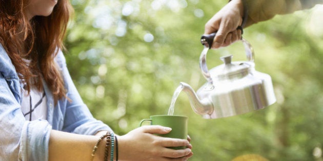 woman holding cup of tea in forest