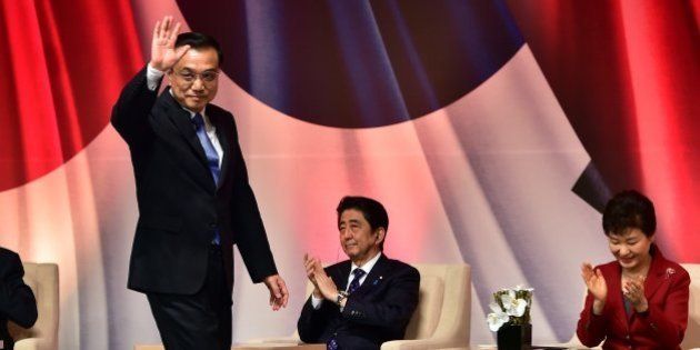 Chinese Premier Li Keqiang (2nd L) waves after his speech as South Korean President Park Geun-Hye (R) and Japanese Prime Minister Shinzo Abe (2nd R) applaud during a business summit in Seoul on November 1, 2015. The leaders of South Korea, China and Japan held their first summit in more than three years on November 1, setting aside historical animosities and territorial disputes to focus on shared security and trade concerns. AFP PHOTO / POOL / JUNG YEON-JE (Photo credit should read JUNG YEON-JE/AFP/Getty Images)