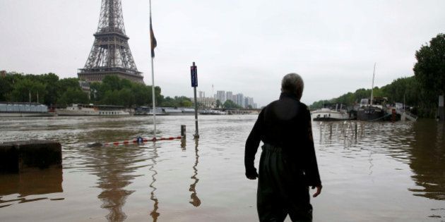 A man walks on a flooded road near his houseboat moored near the Eiffel towel during flooding on the banks of the Seine River in Paris, France, after days of almost non-stop rain caused flooding in the country June 2, 2016. REUTERS/Pascal Rossignol TPX IMAGES OF THE DAY
