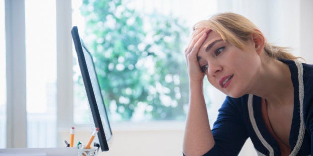 Frustrated Caucasian businesswoman using computer