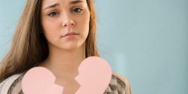 Hispanic girl holding broken heart shape