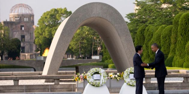 U.S. President Barack Obama, right, and Japanese Prime Minister Shinzo Abe shake hands during a wreath laying ceremony at the cenotaph at Hiroshima Peace Memorial Park in Hiroshima, western, Japan, Friday, May 27, 2016. Obama on Friday became the first sitting U.S. president to visit the site of the world's first atomic bomb attack, bringing global attention both to survivors and to his unfulfilled vision of a world without nuclear weapons. Atomic Bomb Dome is seen in the background. (AP Photo/Carolyn Kaster)