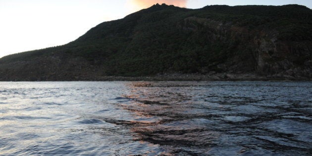 The sun rises as a flotilla of ships (not pictured) approaches a group of islands (C) known as Senkaku in Japanese and Diaoyu in Chinese, early on August 19, 2012. Nationalists raised Japanese flags on an island at the heart of a corrosive territorial row on August 19, sparking street protests in China and an angry reaction from Beijing. AFP PHOTO / Antoine Bouthier (Photo credit should read ANTOINE BOUTHIER/AFP/GettyImages)