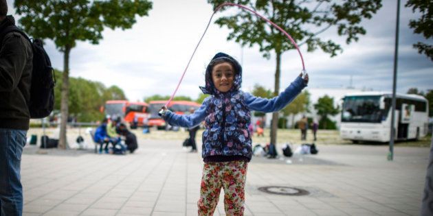 MUNICH, GERMANY - SEPTEMBER 07: Dima, 5, from Syria plays with a skipping rope at a refugee accomodation facility in an exhibition hall on September 7, 2015 in Munich, Germany. German authorities are expecting 10,000 migrants to arrive on trains today, mostly from Hungary via Austria, on top of the approximately 20,000 that have arrived in the last 48 hours. Germany is distributing the migrants across the country and is struggling to register and house them. Many of the migrants are coming from Syria, Afghanistan and Iraq and are reaching western Europe via the Balkans. (Photo by Philipp Guelland/Getty Images)