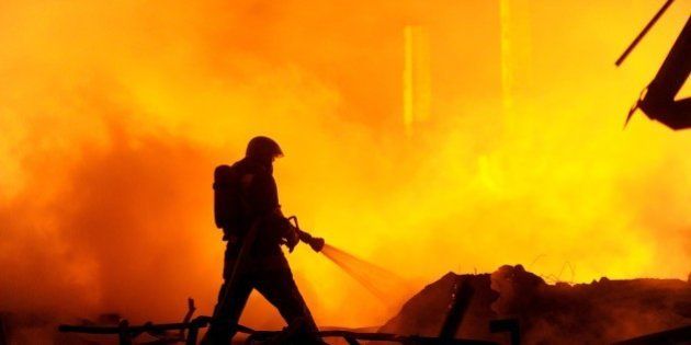A firefighter works to extinguish a fire at a warehouse of car spare parts in St. Petersburg on October 17, 2015. AFP PHOTO / OLGA MALTSEVA (Photo credit should read OLGA MALTSEVA/AFP/Getty Images)