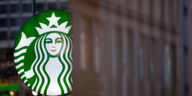 A Starbucks Corp. logo hangs outside one of the company's coffee shops in Berlin, Germany, on Tuesday, May 28, 2013. Starbucks, the world's biggest coffee-shop operator, reported fiscal second-quarter profit in April that met analysts' estimates as U.S. customer traffic improved while sales stagnated in Europe. Photographer: Krisztian Bocsi/Bloomberg via Getty Images