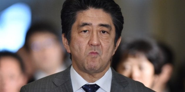 Japan's Prime Minister Shinzo Abe (C) arrives at the National Diet to attend a budget committee session of the House of Representatives in Tokyo on January 30, 2015. The wife of Japanese journalist Kenji Goto, who is being threatened with execution by Islamic State militants, broke her silence on January 29, hours before the deadline for a hostage swap that could save his life. AFP PHOTO / KAZUHIRO NOGI (Photo credit should read KAZUHIRO NOGI/AFP/Getty Images)