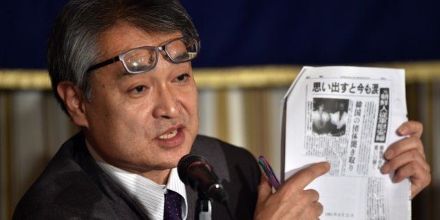 Former reporter with Japanese newspaper Asahi Shimbun, Takashi Uemura, displays a copy of an article about Korean comfort women written by him for the Asahi Shimbun at a news conference in Tokyo on January 9, 2015. The former journalist whose articles about Japan's military brothels angered conservatives and helped stir longstanding debate over Tokyo's wartime record on January 9 sued a publisher and an academic for labelling his stories a 'fabrication'. AFP PHOTO / Yoshikazu TSUNO (Photo credit should read YOSHIKAZU TSUNO/AFP/Getty Images)