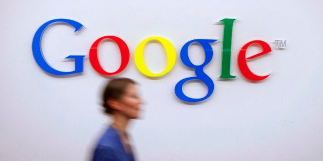 A Google Inc. employee walks past a logo outside the entrance to the company's offices in Berlin, Germany, on Friday, Aug. 16, 2013. Google, based in Mountain View, California, is seeking to revive Motorola Mobility's smartphone business, recently announcing a new flagship Moto X smartphone with customizable colors that will be assembled in the U.S. Photographer: Krisztian Bocsi/Bloomberg via Getty Images