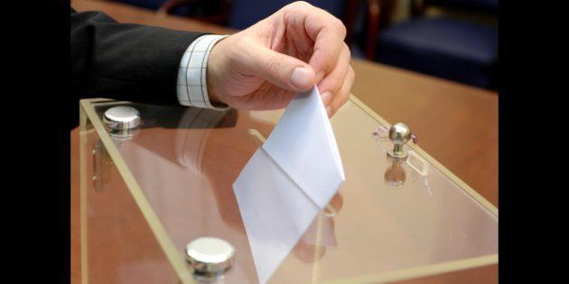 ballot box and hand putting a blank ballot inside, elections and democracy concept