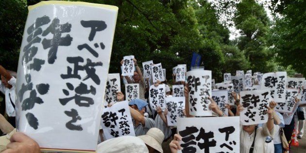 Protesters display placards during an anti-government rally outside the National Diet in Tokyo on July 18, 2015. Controversial security bills that opponents say will undermine 70 years of pacifism and could see Japanese troops fighting abroad for the first time since World War II, passed through the powerful lower house of parliament July 16. AFP PHOTO / KAZUHIRO NOGI (Photo credit should read KAZUHIRO NOGI/AFP/Getty Images)