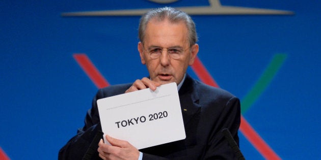 International Olympic Committee (IOC) President Jacques Rogge shows the name of the city of Tokyo elected to host the 2020 Summer Olympics in Buenos Aires, Argentina, Saturday, Sept. 7, 2013. (AP Photo/Fabrice Coffrini, Pool)