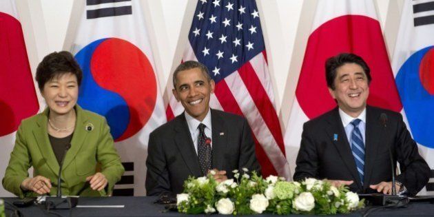 (L-R) South Korean President Park Geun-hye, US President Barack Obama and Japanese Prime Minister Shinzo Abe hold a trilateral meeting at the US ambassador's residence in The Hague on March 25, 2014 after they attended the Nuclear Security Summit (NSS). Obama hosted the much-anticipated first meeting between the Asian leaders with relations between Tokyo and Seoul at their lowest ebb in years, mired in emotive issues linked to Japan's 1910-45 colonial rule and a territorial dispute, as well as Japan's use of South Korean 'comfort women' sex slaves in wartime brothels. AFP PHOTO / Saul LOEB (Photo credit should read SAUL LOEB/AFP/Getty Images)