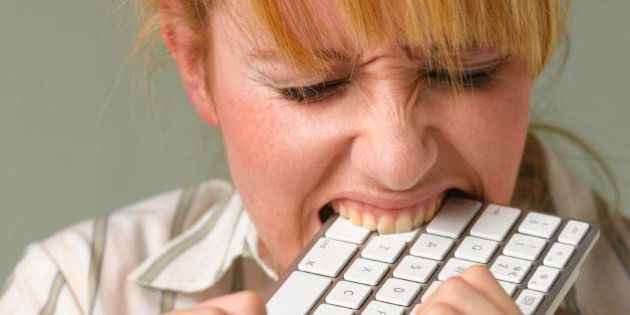 Young woman biting keyboard