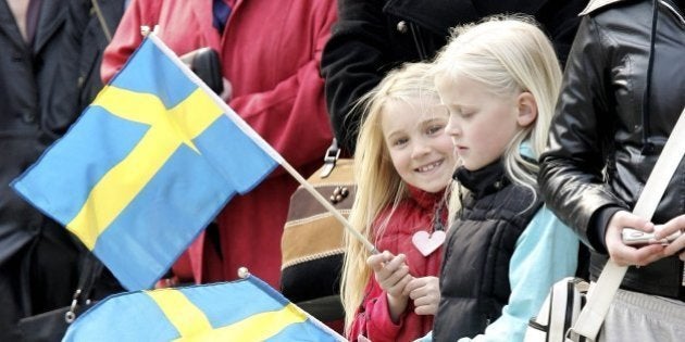 STOCKHOLM, SWEDEN - APRIL 30: Young girls wave Swedish flags during the changing of the guard on H.M. King Carl XVI Gustaf of Swedens 60th birthday at the Stockholm Royal Palace on April 30, 2006 in Stockholm, Sweden. (Photo by Chris Jackson/Getty Images)