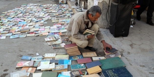 In this Friday, Jan. 23, 2015 photo, an Iraqi man looks at books on al-Mutanabi Street, home to the city's book market in central Baghdad. One afternoon this month, Islamic State militants arrived at the Central Library of the northern city of Mosul in a non-combat mission. They broke the locks that kept the two-story building closed since the extremists overran the city in mid last year, loading some 2,000 books included children stories, poetry, philosophy, sports, health and cultural and scientific publications into six pickup trucks and leaving behind only the Islamic religious ones. (AP Photo/Karim Kadim)