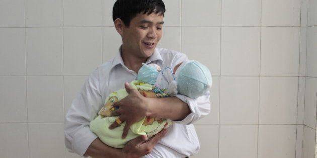 CAO BANG CITY, CAO BANG, VIETNAM - 2011/04/25: A father with his new born baby in Cao Bang provincial hospital. The World Health Report 2005 Ã Make Every Mother and Child Count, says that in that year almost 11 million children under five years of age will die from causes that are largely preventable. Among them are 4 million babies who will not survive the first month of life. At the same time, more than half a million women will die in pregnancy, childbirth or soon after. The report says that reducing this toll in line with the Millennium Development Goals depends largely on every mother and every child having the right to access to health care from pregnancy through childbirth, the neonatal period and childhood. new born, baby, mother, father, family, breast feeding, hostpital. (Photo by Chau Doan/LightRocket via Getty Images)