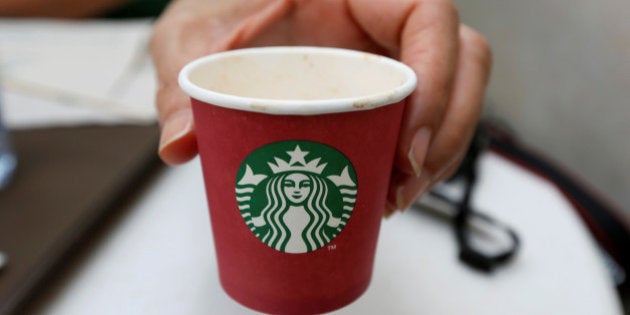 A woman displays a red Starbucks cup at a Starbucks cafe in Beirut, Lebanon November 20, 2016. Picture taken November 20, 2016. REUTERS/Jamal Saidi