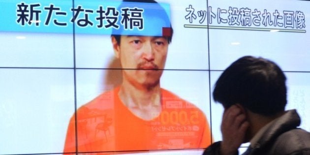 A pedestrian looks at a large screen in Tokyo on January 28, 2015 showing television news reports about Japanese hostage Kenji Goto who has been kidnapped by the Islamic State group. Japan has asked Jordan for help after the Islamic State jihadist group threatened to kill a Japanese journalist and a Jordanian pilot within 24 hours unless Amman frees a jailed female militant. AFP PHOTO / KAZUHIRO NOGI (Photo credit should read KAZUHIRO NOGI/AFP/Getty Images)