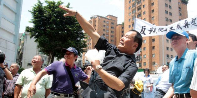 In protest of the Japanese coast guard recently detaining a Taiwanese fishing boat, fishermen hurl eggs outside of the Japan representative office in Taipei, Taiwan, Wednesday, April 27, 2016. Scores of Taiwanese fishermen protested Wednesday outside Japanâs representative office in Taiwan to demand an apology over the seizure of one of their fishing boats by the Japanese coast guard. (AP Photo/ Chiang Ying-ying)