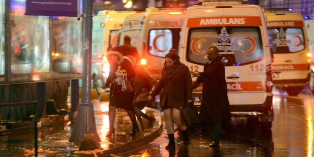 People flee as ambulances are on the attack site on January 1, 2017 in Istanbul. At least two people were killed in an armed attack Saturday on an Istanbul nightclub where people were celebrating the New Year, Turkish television reports said. / AFP / IHLAS NEWS AGENCY / IHLAS NEWS AGENCY (Photo credit should read IHLAS NEWS AGENCY/AFP/Getty Images)